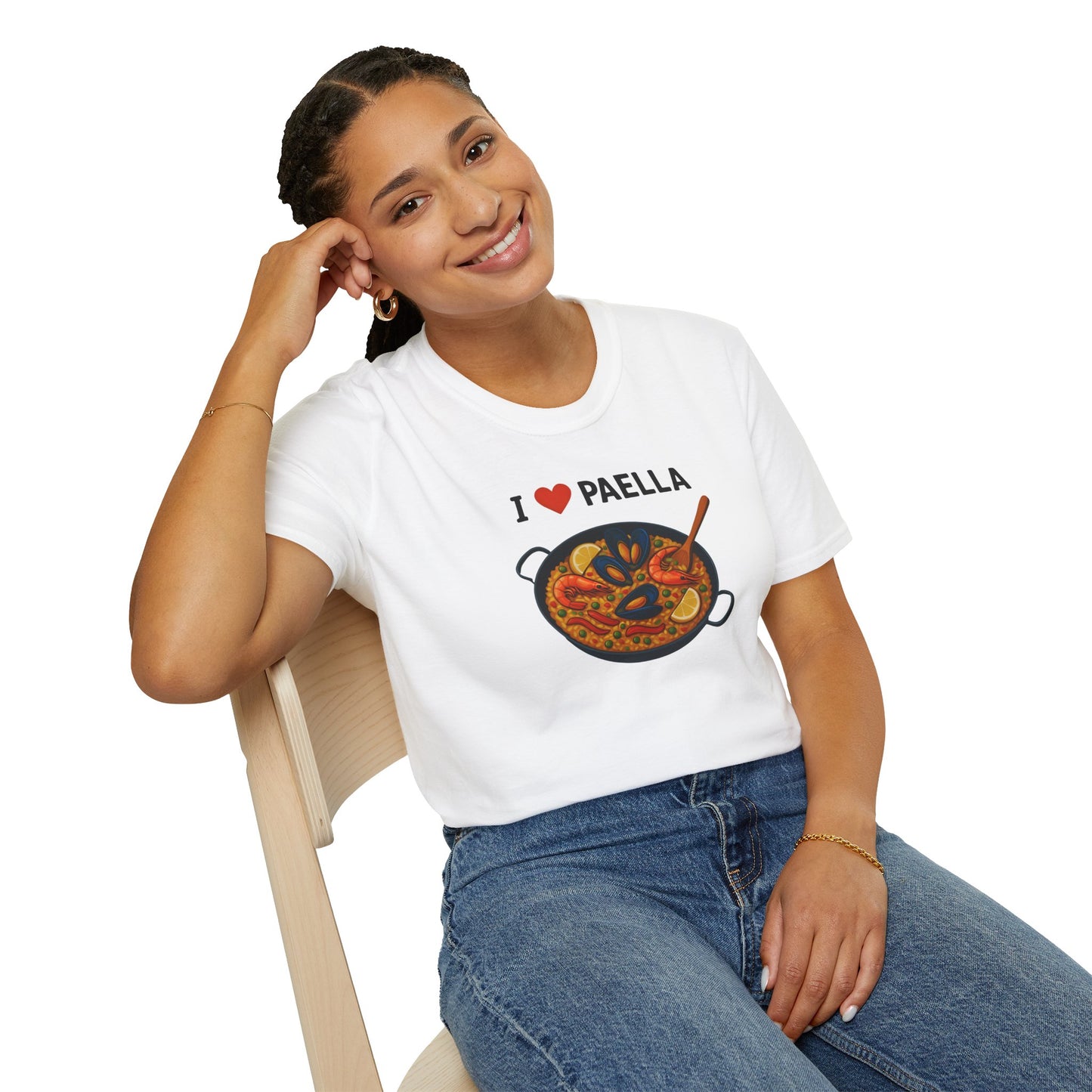 Person wearing a white t-shirt with 'I ❤️ Paella' design, sitting on a chair.