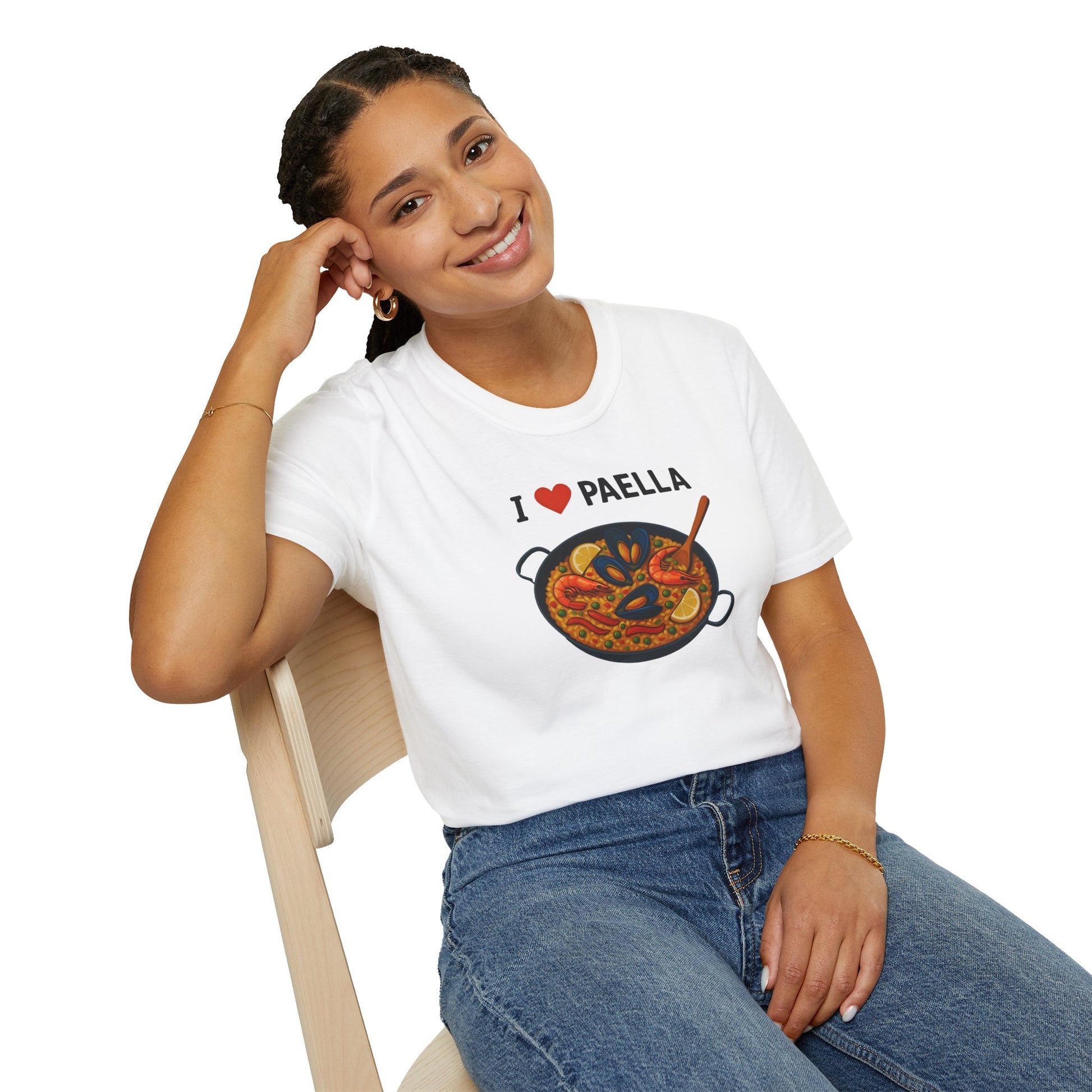 Person wearing a white t-shirt with 'I ❤️ Paella' design, sitting on a chair.